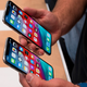 Someone with larger hands demonstrates the difference between the Xs and Xs Max